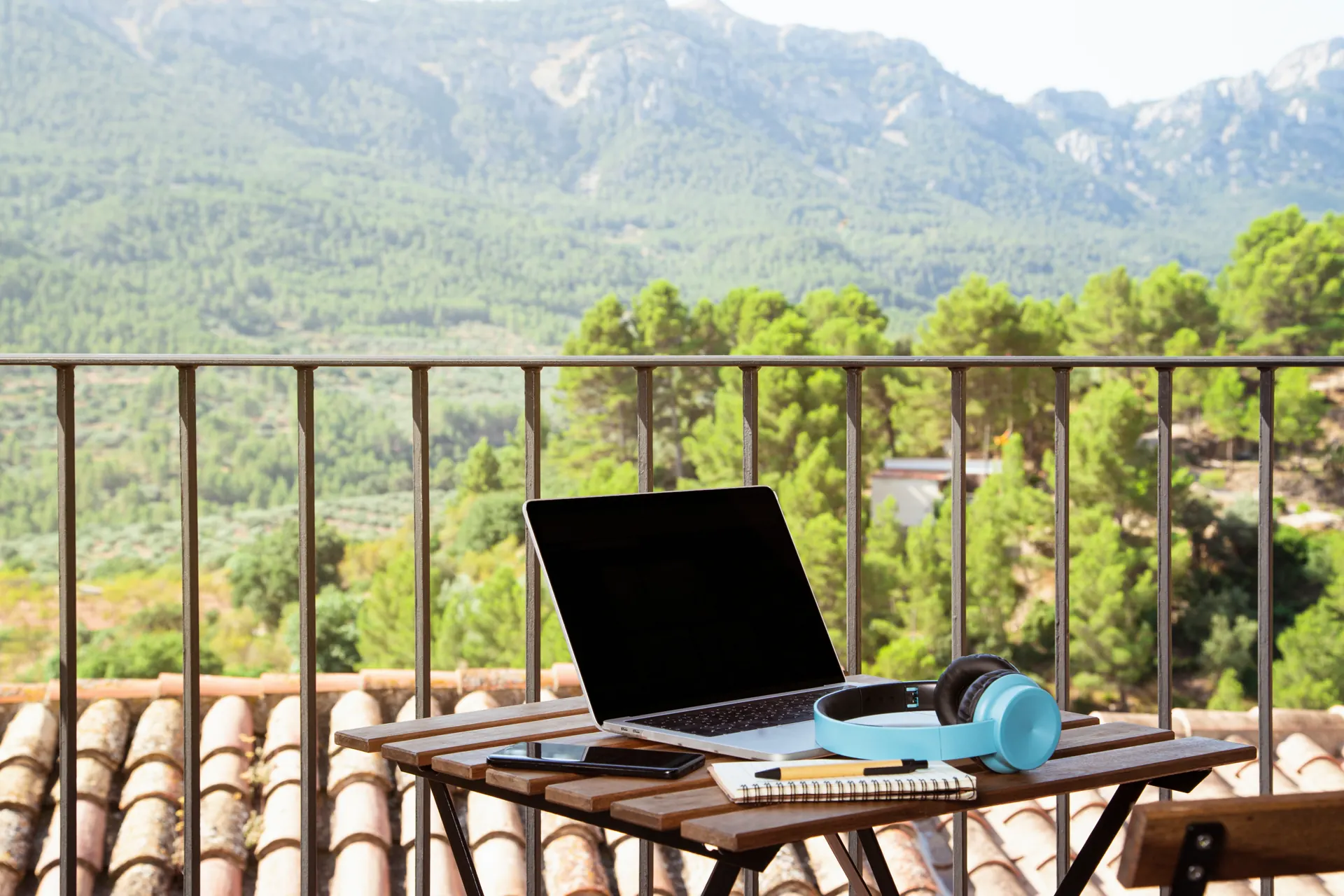 Portátil en una terraza con vistas a la montaña