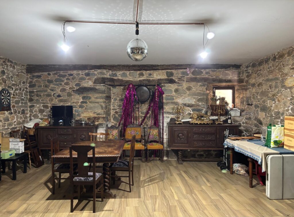 Salón rústico con paredes de piedra vista y techos de madera
